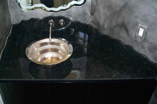 vessel sink vanity bathroom vanities custom It's difficult to appreciate the beautiful effect in this black, shattered glass vanity. The photo doesn't show the sparkling, beautiful details enough. The vessel is a polished steel. The backsplash is chiseled irregular and we did a mirror above to compliment that features a carved texture around the irregular edge border.