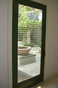 View from inside the house, looking through the glass to courtyard, entry.